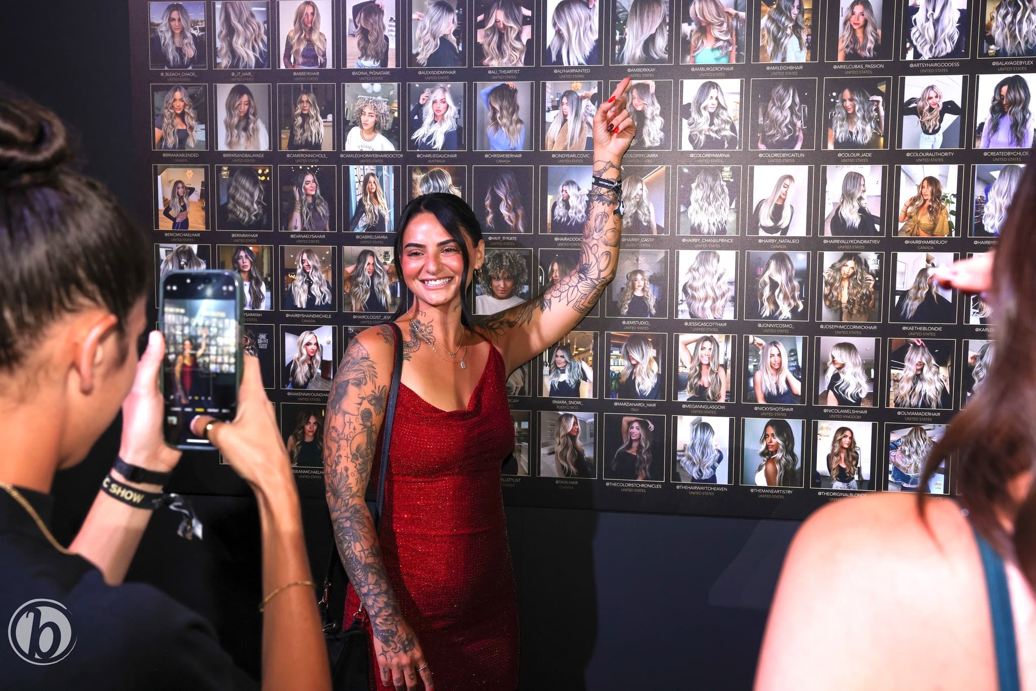 #ONESHOT nominee posing in front of the gallery wall of nominee photos